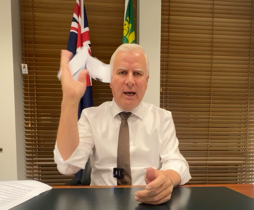 man speaking while sitting at his office desk 